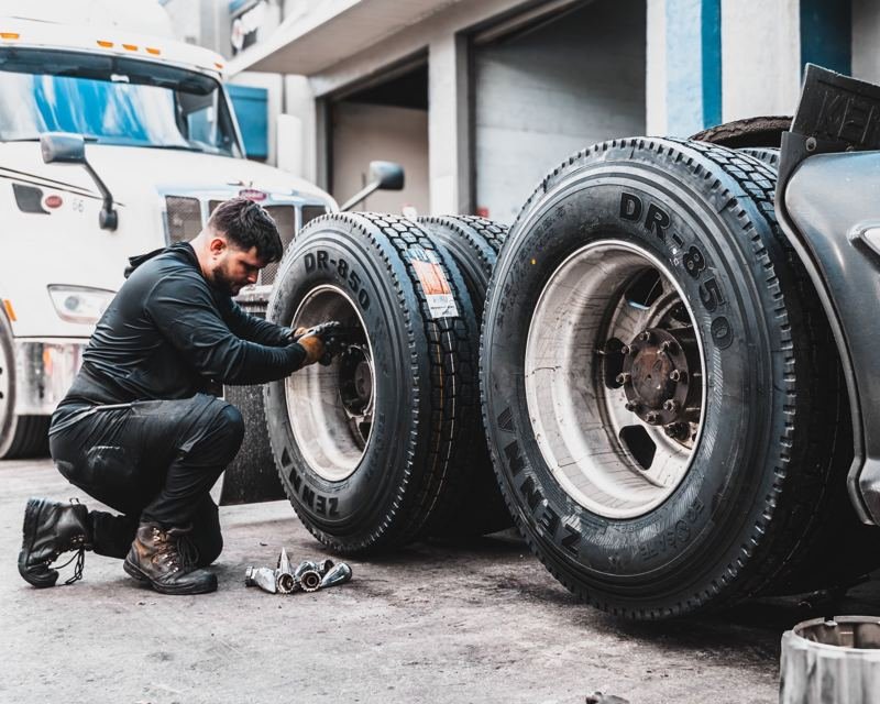 Technician installing tires on a semi-truck